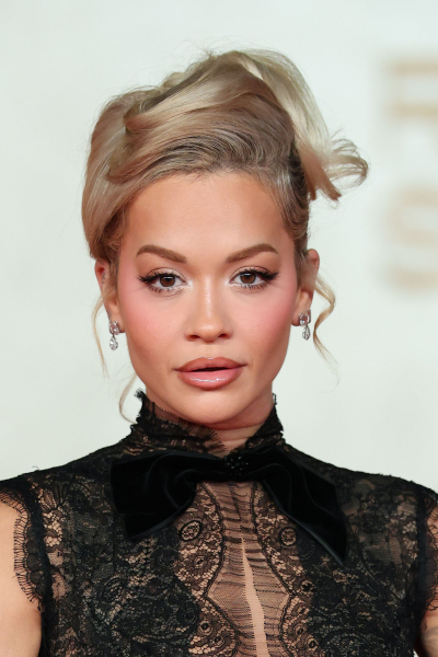 Rita Ora posing in a black lace dress